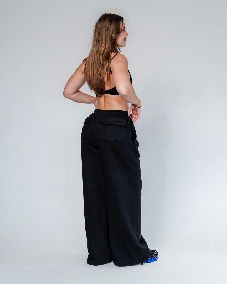 Vores Wide Leg Sweatpants kombinerer afslappet komfort med moderne design. Med et oversized fit falder bukserne flot og giver et casual look. Bukserne har baglommer med et subtilt embossed logo, der tilføjer et eksklusivt touch. Bukserne har snøre i taljen for en justerbar pasform – og snørerne i anklerne giver dig mulighed for at style dem, som du vil: lad dem hænge løst for det klassiske wide leg-look, eller snør dem ind for et mere tapered udtryk.