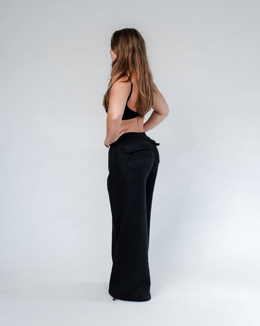 Vores Wide Leg Sweatpants kombinerer afslappet komfort med moderne design. Med et oversized fit falder bukserne flot og giver et casual look. Bukserne har baglommer med et subtilt embossed logo, der tilføjer et eksklusivt touch. Bukserne har snøre i taljen for en justerbar pasform – og snørerne i anklerne giver dig mulighed for at style dem, som du vil: lad dem hænge løst for det klassiske wide leg-look, eller snør dem ind for et mere tapered udtryk.
