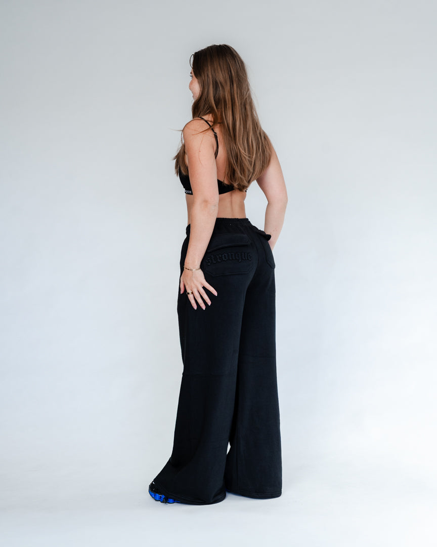 Vores Wide Leg Sweatpants kombinerer afslappet komfort med moderne design. Med et oversized fit falder bukserne flot og giver et casual look. Bukserne har baglommer med et subtilt embossed logo, der tilføjer et eksklusivt touch. Bukserne har snøre i taljen for en justerbar pasform – og snørerne i anklerne giver dig mulighed for at style dem, som du vil: lad dem hænge løst for det klassiske wide leg-look, eller snør dem ind for et mere tapered udtryk.