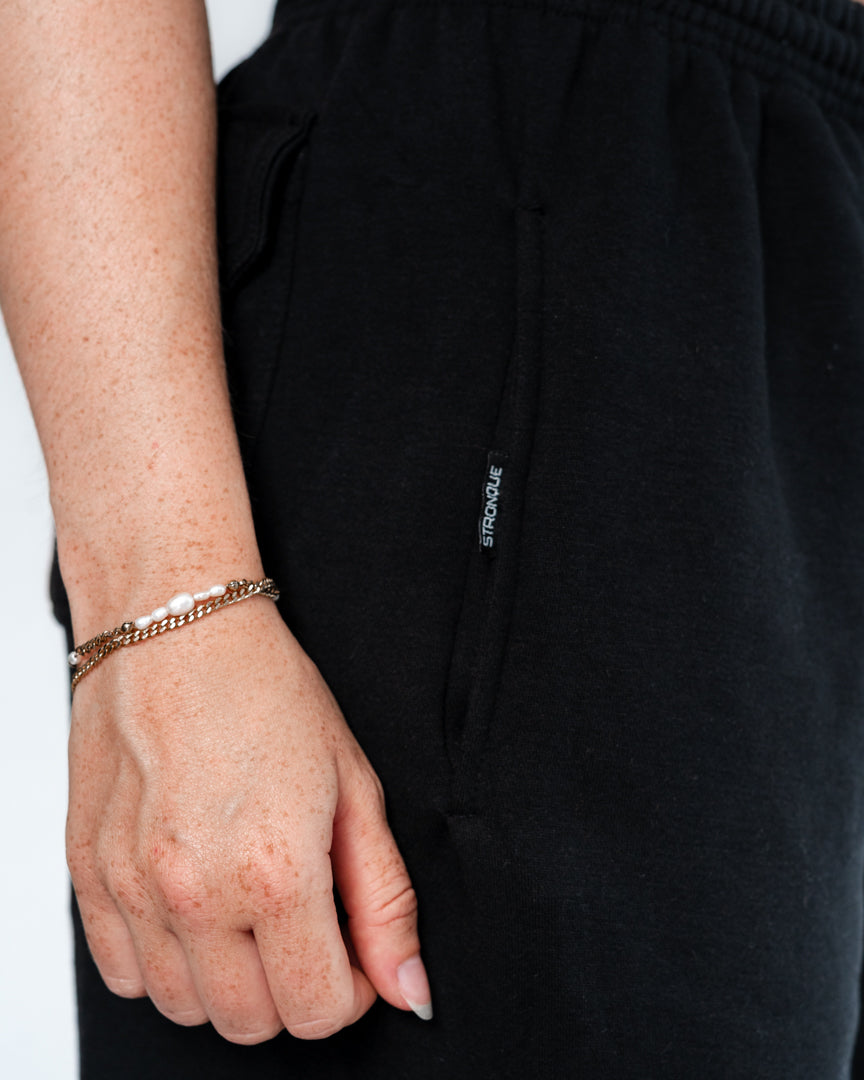 Vores Wide Leg Sweatpants kombinerer afslappet komfort med moderne design. Med et oversized fit falder bukserne flot og giver et casual look. Bukserne har baglommer med et subtilt embossed logo, der tilføjer et eksklusivt touch. Bukserne har snøre i taljen for en justerbar pasform – og snørerne i anklerne giver dig mulighed for at style dem, som du vil: lad dem hænge løst for det klassiske wide leg-look, eller snør dem ind for et mere tapered udtryk.