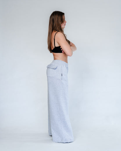 Vores Wide Leg Sweatpants kombinerer afslappet komfort med moderne design. Med et oversized fit falder bukserne flot og giver et casual look. Bukserne har baglommer med et subtilt embossed logo, der tilføjer et eksklusivt touch. Bukserne har snøre i taljen for en justerbar pasform – og snørerne i anklerne giver dig mulighed for at style dem, som du vil: lad dem hænge løst for det klassiske wide leg-look, eller snør dem ind for et mere tapered udtryk.