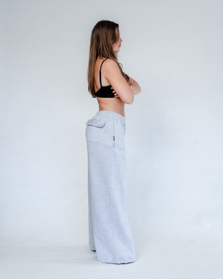 Vores Wide Leg Sweatpants kombinerer afslappet komfort med moderne design. Med et oversized fit falder bukserne flot og giver et casual look. Bukserne har baglommer med et subtilt embossed logo, der tilføjer et eksklusivt touch. Bukserne har snøre i taljen for en justerbar pasform – og snørerne i anklerne giver dig mulighed for at style dem, som du vil: lad dem hænge løst for det klassiske wide leg-look, eller snør dem ind for et mere tapered udtryk.