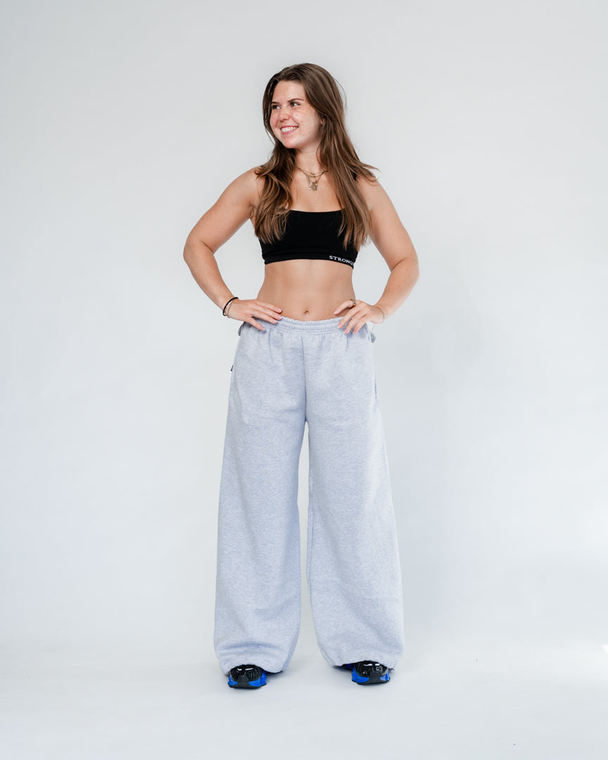 Vores Wide Leg Sweatpants kombinerer afslappet komfort med moderne design. Med et oversized fit falder bukserne flot og giver et casual look. Bukserne har baglommer med et subtilt embossed logo, der tilføjer et eksklusivt touch. Bukserne har snøre i taljen for en justerbar pasform – og snørerne i anklerne giver dig mulighed for at style dem, som du vil: lad dem hænge løst for det klassiske wide leg-look, eller snør dem ind for et mere tapered udtryk.