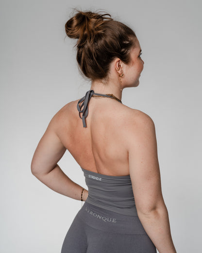 Opdag vores nye halterneck træningstop til kvinder, hvor funktionalitet møder feminint design. Denne top er skabt til den moderne, aktive kvinde og kombinerer stil med støtte – perfekt til både fitness, pilates, styrketræning og hverdagsbrug.

Toppen har en indbygget sports-bh med udtagelige indlæg, som giver dig frihed til at tilpasse støtten. Det justerbare bindebånd i nakken sikrer en personlig pasform, mens den diskrete push up-effekt løfter og former for en smigrende, feminin silhuet.