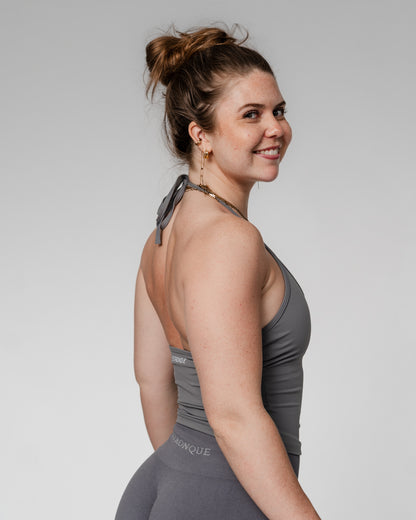 Opdag vores nye halterneck træningstop til kvinder, hvor funktionalitet møder feminint design. Denne top er skabt til den moderne, aktive kvinde og kombinerer stil med støtte – perfekt til både fitness, pilates, styrketræning og hverdagsbrug.

Toppen har en indbygget sports-bh med udtagelige indlæg, som giver dig frihed til at tilpasse støtten. Det justerbare bindebånd i nakken sikrer en personlig pasform, mens den diskrete push up-effekt løfter og former for en smigrende, feminin silhuet.