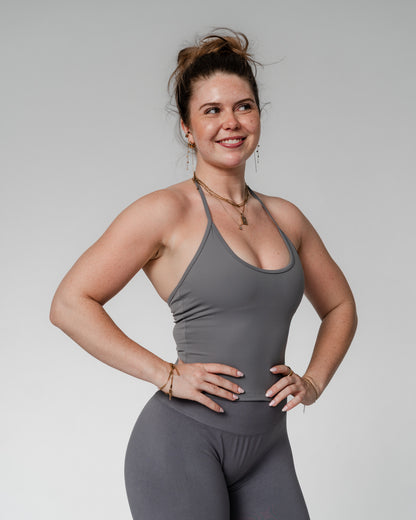 Opdag vores nye halterneck træningstop til kvinder, hvor funktionalitet møder feminint design. Denne top er skabt til den moderne, aktive kvinde og kombinerer stil med støtte – perfekt til både fitness, pilates, styrketræning og hverdagsbrug.

Toppen har en indbygget sports-bh med udtagelige indlæg, som giver dig frihed til at tilpasse støtten. Det justerbare bindebånd i nakken sikrer en personlig pasform, mens den diskrete push up-effekt løfter og former for en smigrende, feminin silhuet.